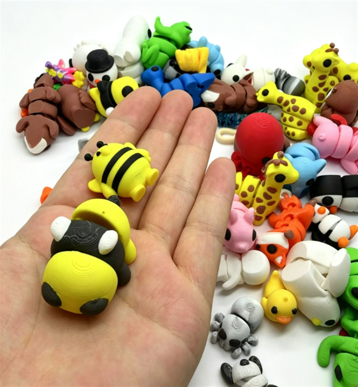 Eine Hand hält zwei Bienenfiguren, jede etwa so groß wie ein Daumen